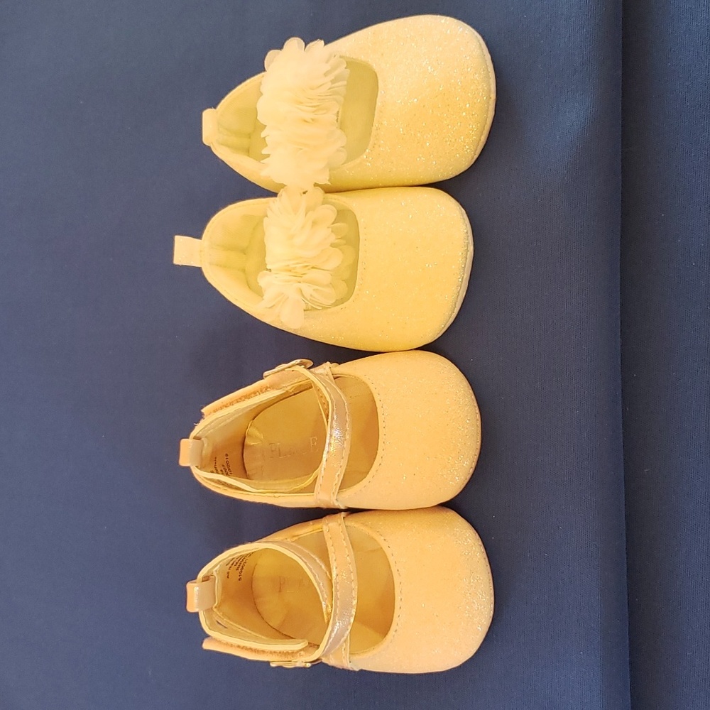Two pairs of baby girl shoes.